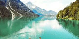 Stand-up-peddelen over azuurblauwe Alpenmeren Stand-up-peddelen over azuurblauwe Alpenmeren